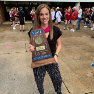 Mattie holding a volleyball state championship plaque