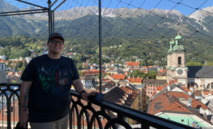 Brandon standing in front of a mountain scape in Austria