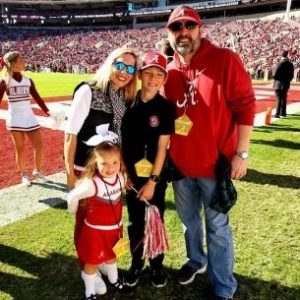 Jessica and her family on the field at Bryant-Denny Stadium during a game