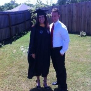Jessica with her husband in her graduation robe when she graduated with her MSW