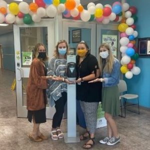Katie and three other teachers in facemasks near a hand sanitizer station